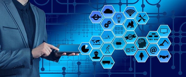 Industry 4.0 graphic of a man holding a phone, a group of hexagonal tiles with logos off to the side